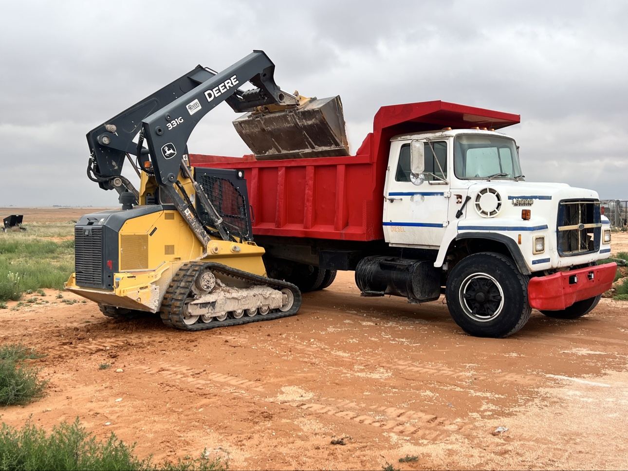 Skid steer loading material into a Can You Dig It dump truck